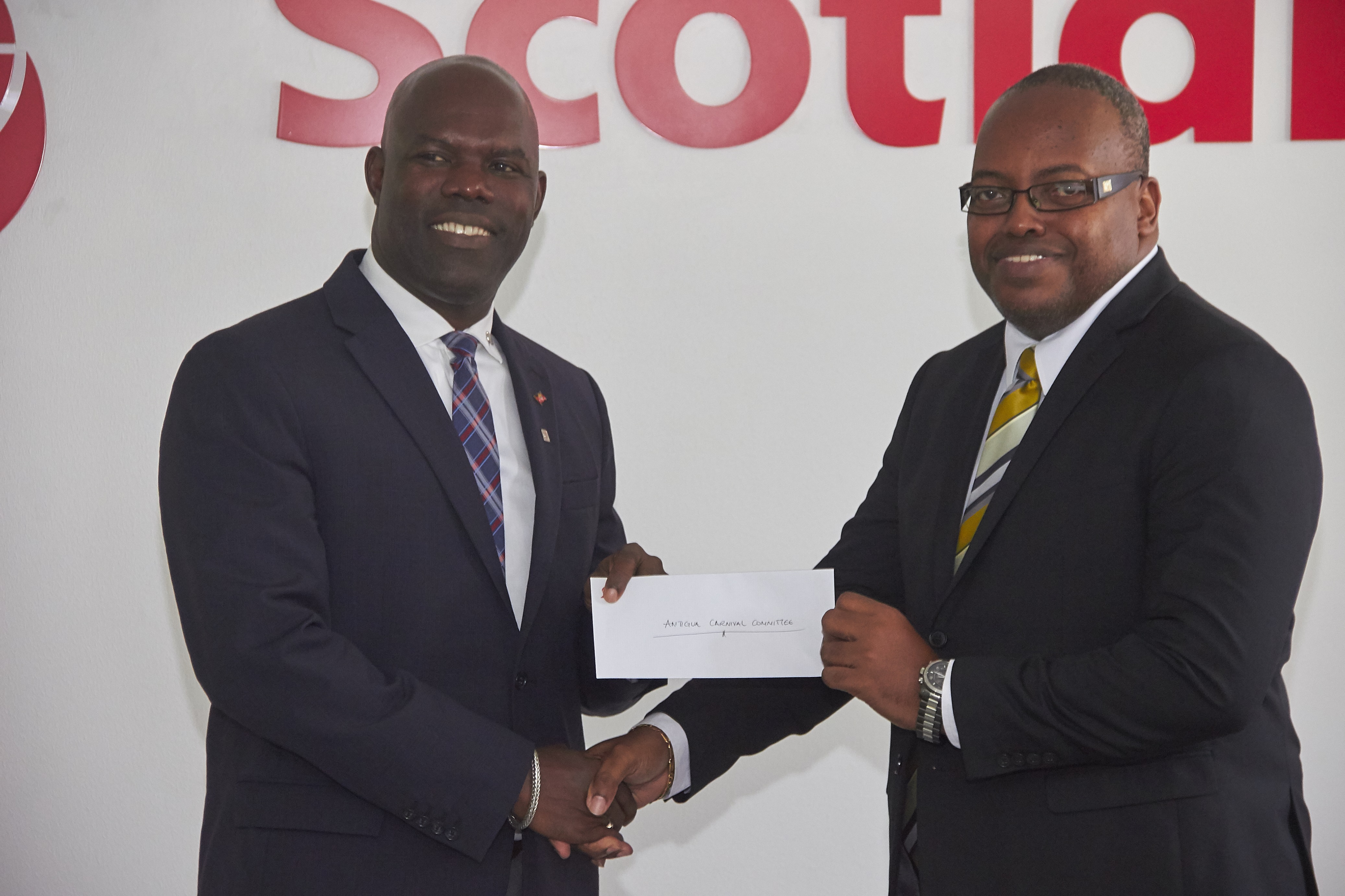 Chairman Of ABFC Maurice Merchant Accepts Cheque From Scotiabank Country Manager Gordon Julien